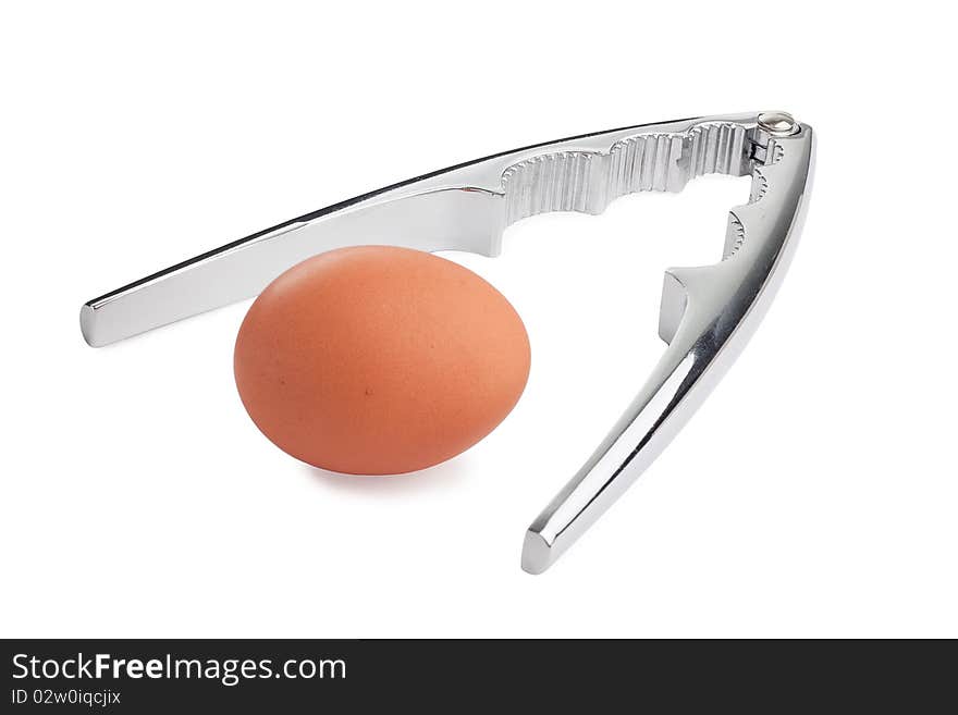 Stainless steel nut cracker with brown egg, isolated on white