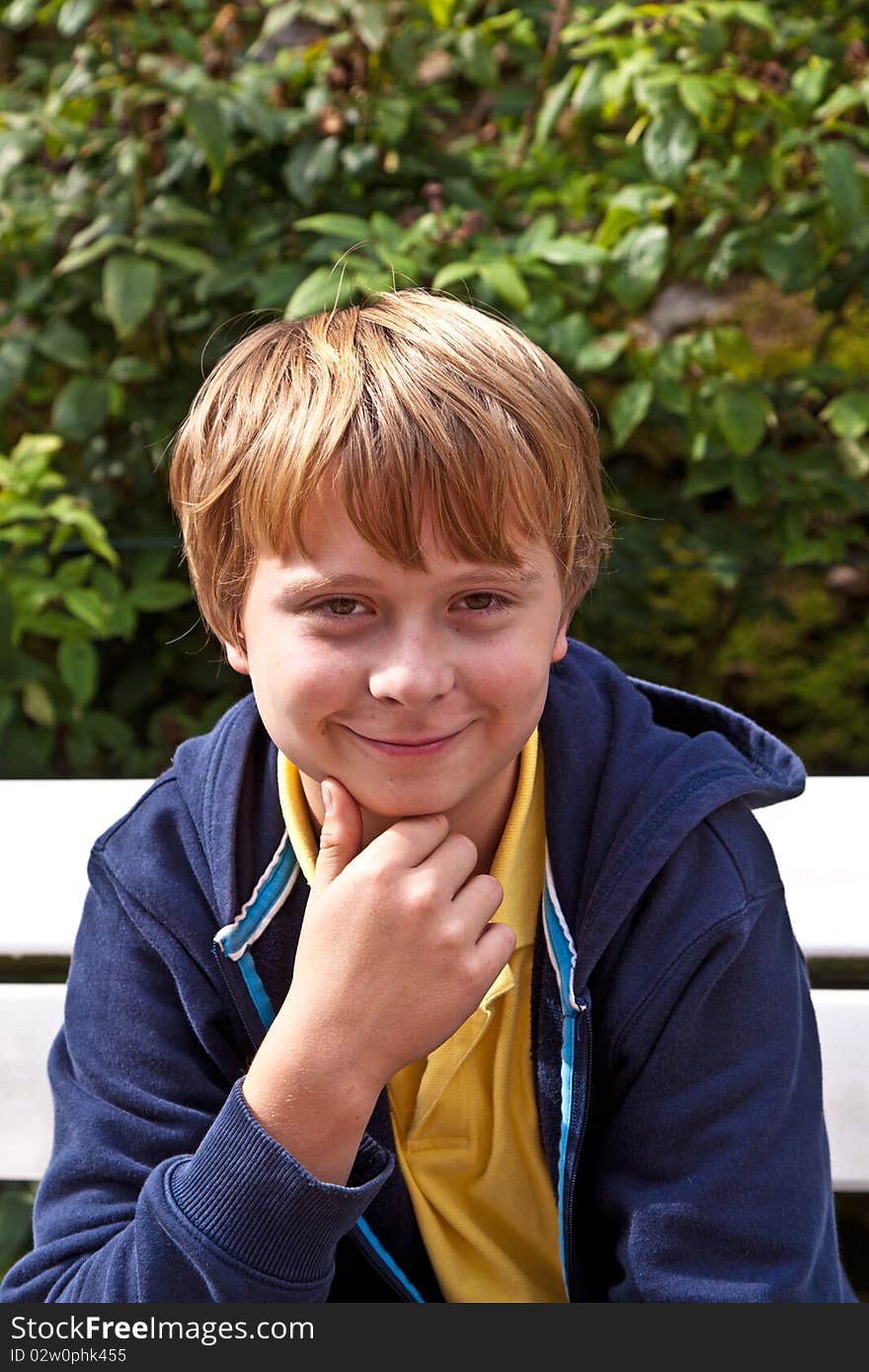 Boy sitting on a bench in a park