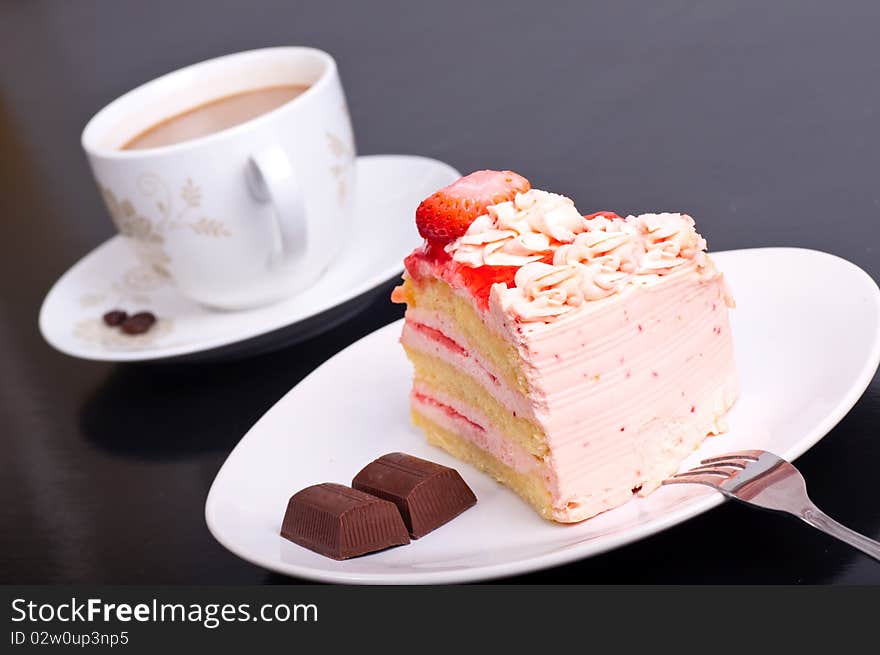 Strawberry cake dessert with cup of cafe on black background
