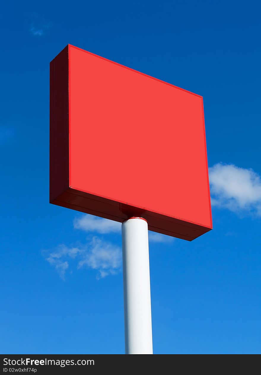 Red blank billboard on a sunny day with blue sky