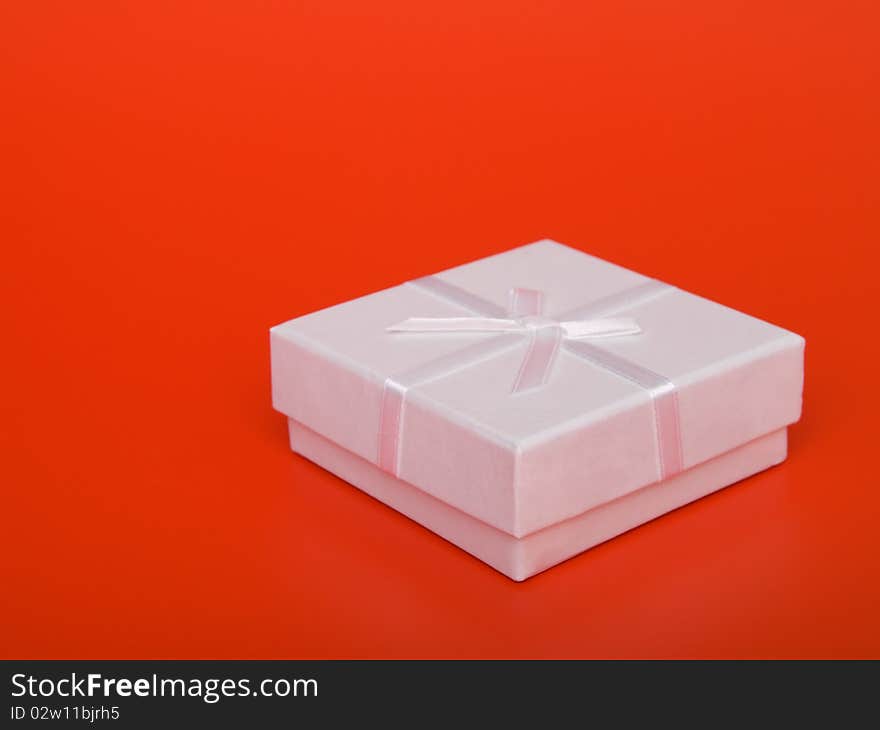 Gift box with ribbons, on  red background