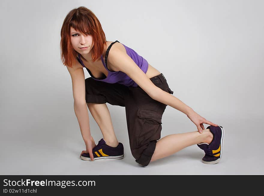 Girl in hip-hop clothes sitting on one knee