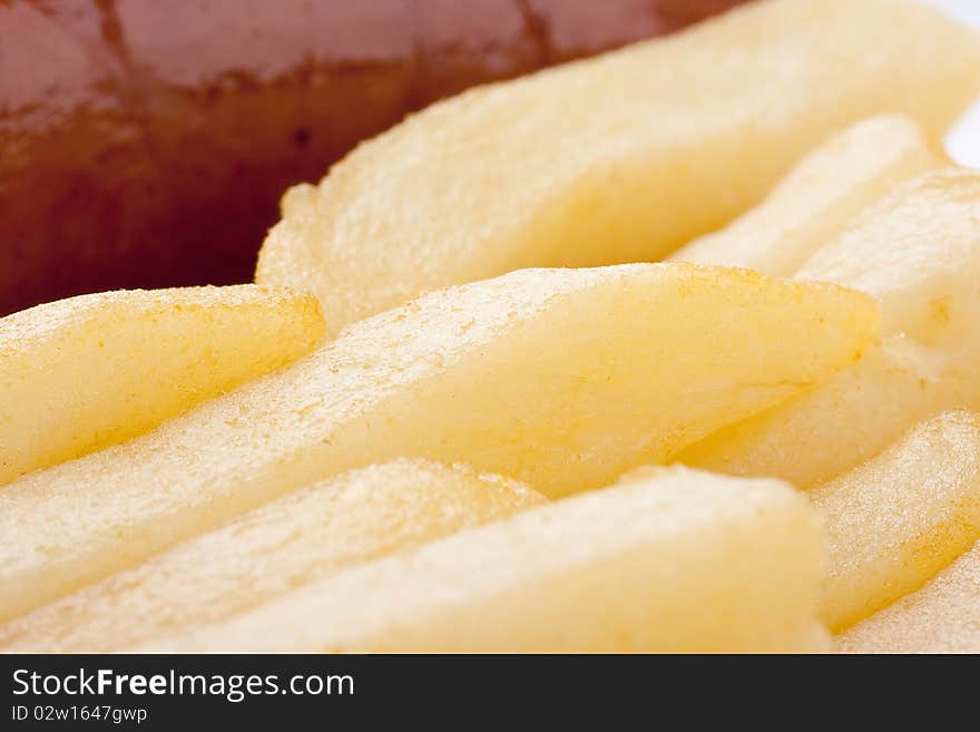 Sausage with a fried potato in a plate.