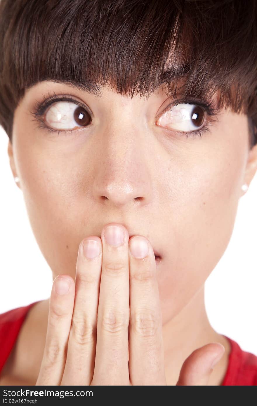 A woman looking side ways with her hand over her mouth.