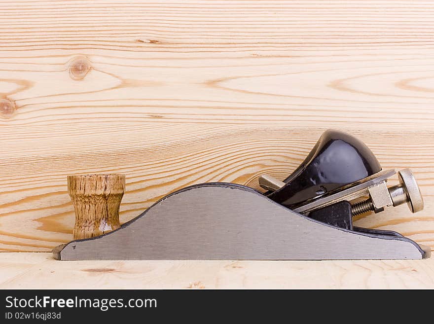 Handplane next to a piece of wood. Add your text to the background.