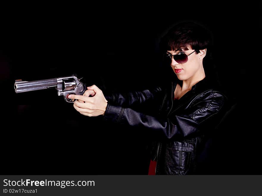 A woman wearing sunglasses pointing the gun away from the camera. A woman wearing sunglasses pointing the gun away from the camera.