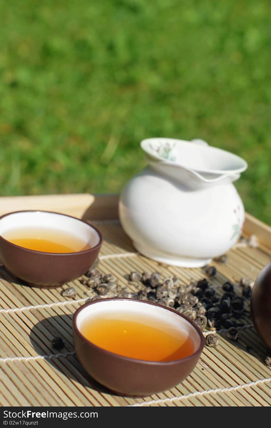 Green tea serving in clay tea pot and two cups