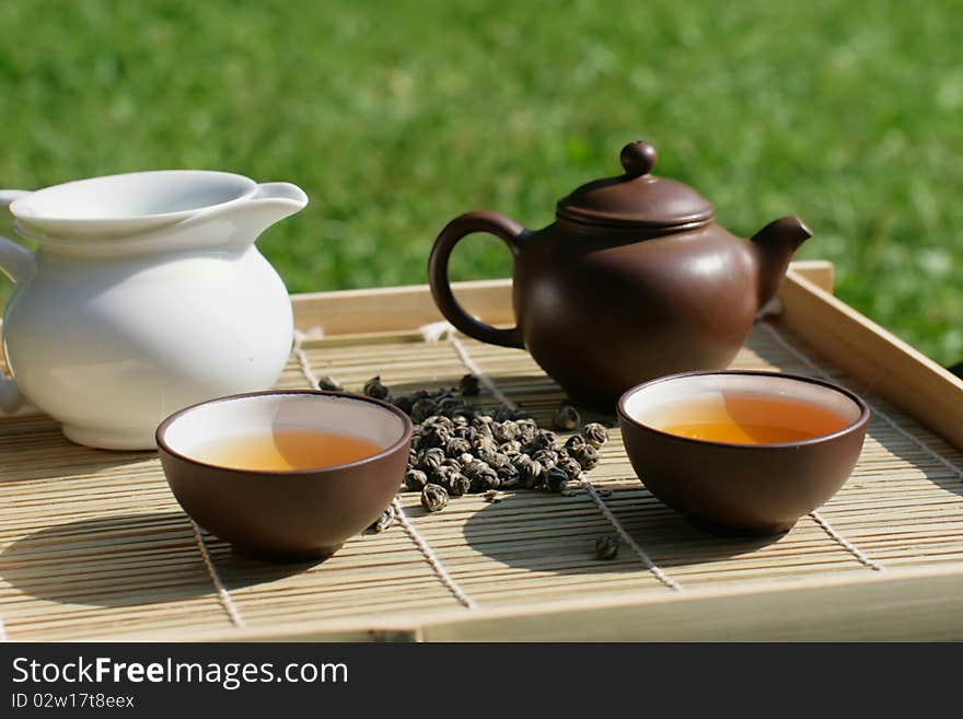 Green tea serving in clay tea pot and two cups