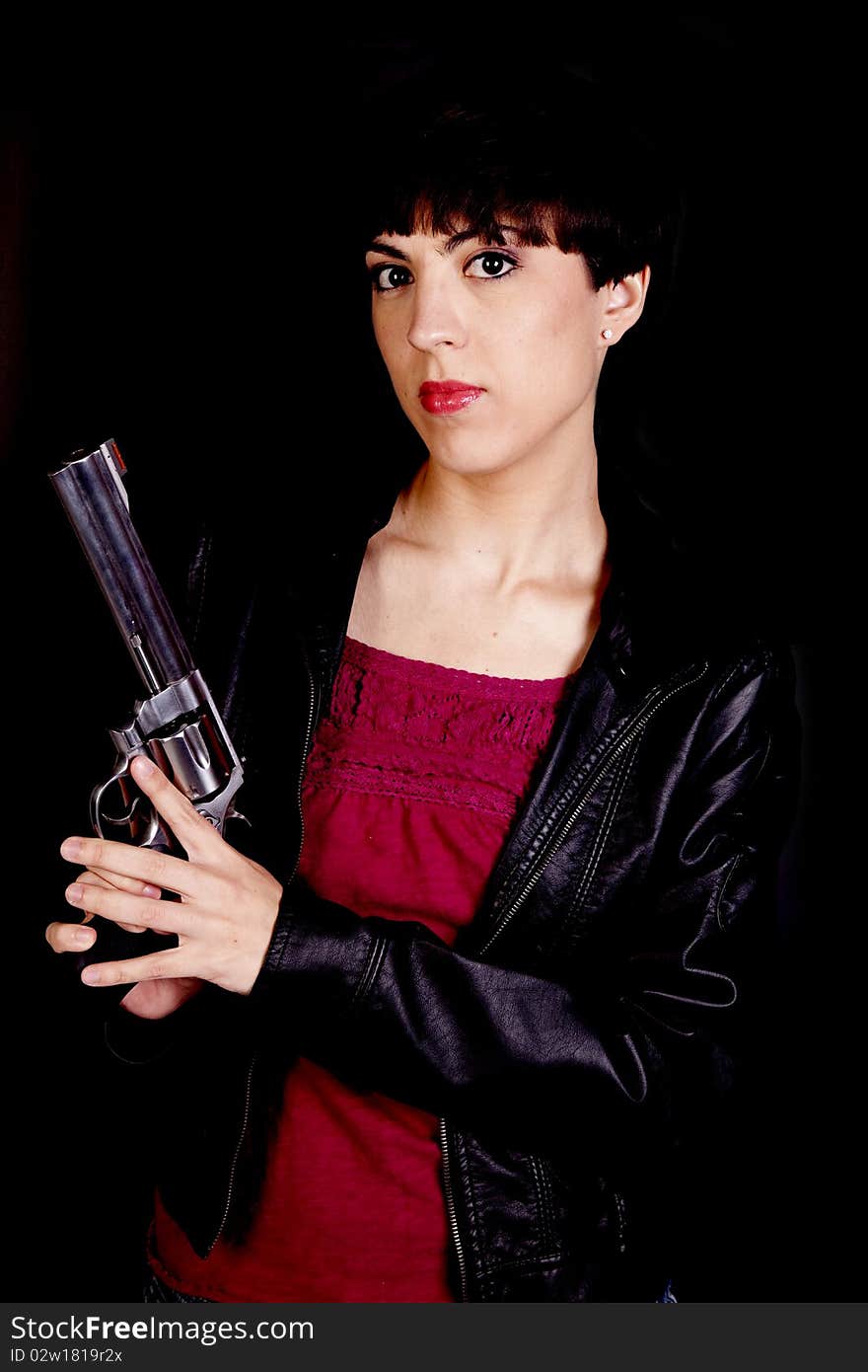 A woman holding a gun with a serious expression on her face. A woman holding a gun with a serious expression on her face.