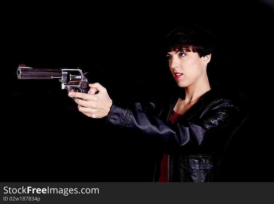 A woman holding her pistol and pointing it away from the camera with a serious expression. A woman holding her pistol and pointing it away from the camera with a serious expression.