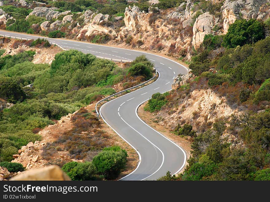 A winding road among the rocks in the landscape barren island of Maddalena. A winding road among the rocks in the landscape barren island of Maddalena