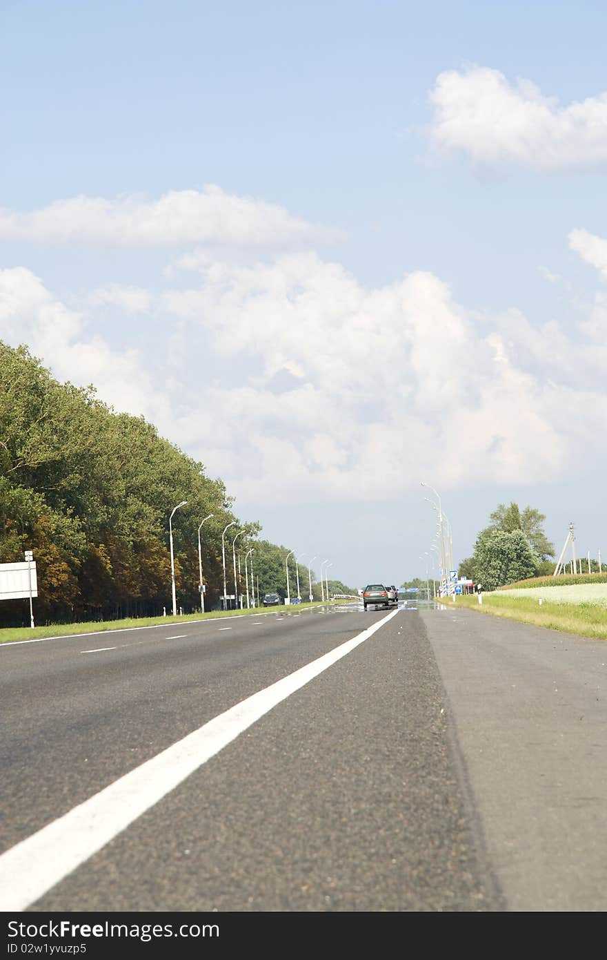 Highway with a road marking and cars which go in the afternoon