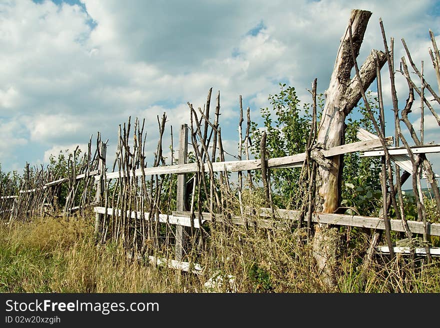 Old wooden fence in the village in summer