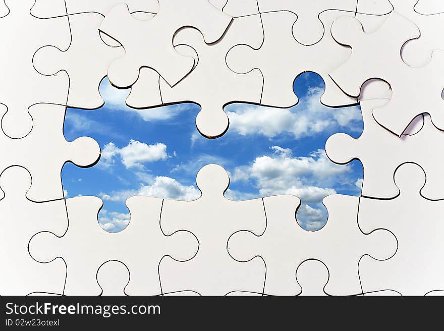 Puzzle background with missing pieces to reveal blue sky with clouds. Puzzle background with missing pieces to reveal blue sky with clouds.