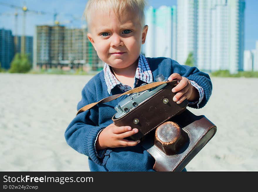 Pretty nice boy playing with a camera outdoors. Pretty nice boy playing with a camera outdoors