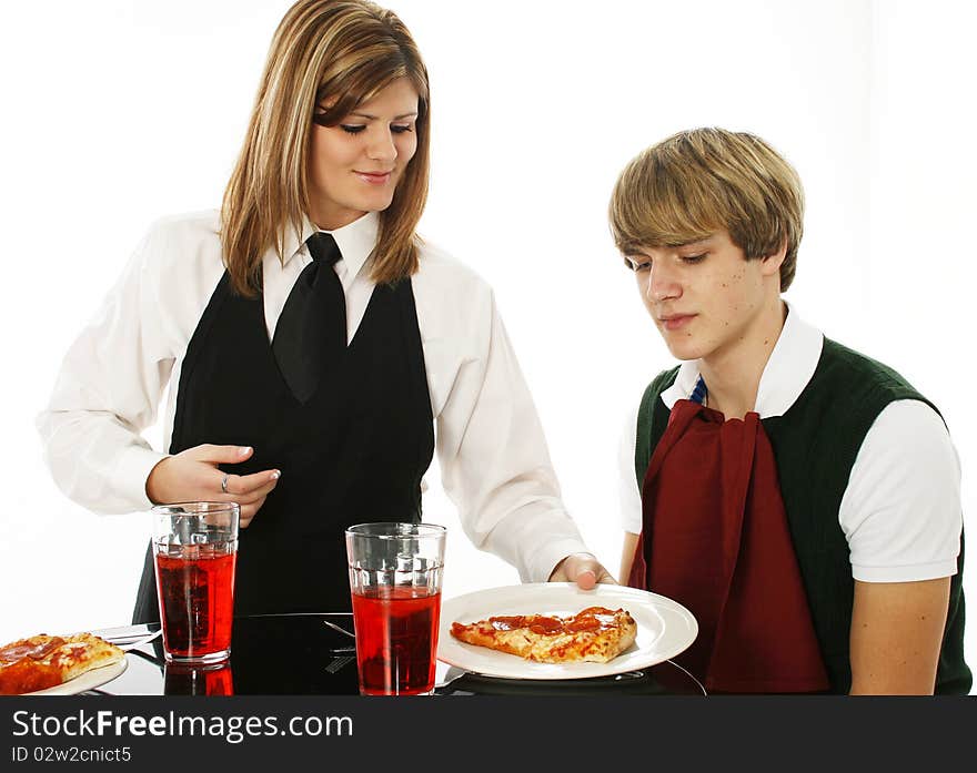 Teen in restaurant getting pizza from waitress over white background. Teen in restaurant getting pizza from waitress over white background.