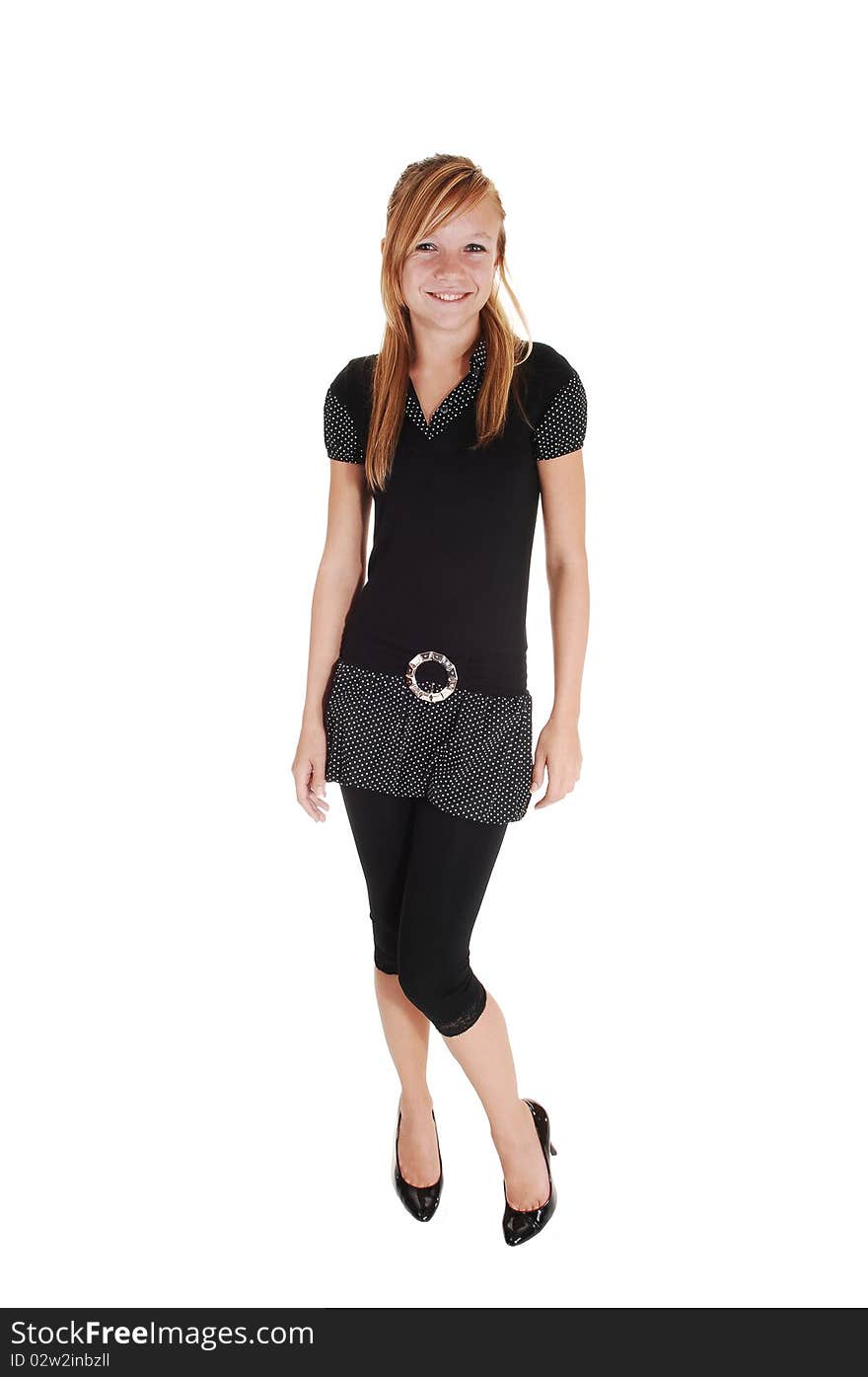 A young pretty woman with long red, blond hair standing in a short black 
dress and stockings, in the studio for white background. A young pretty woman with long red, blond hair standing in a short black 
dress and stockings, in the studio for white background.