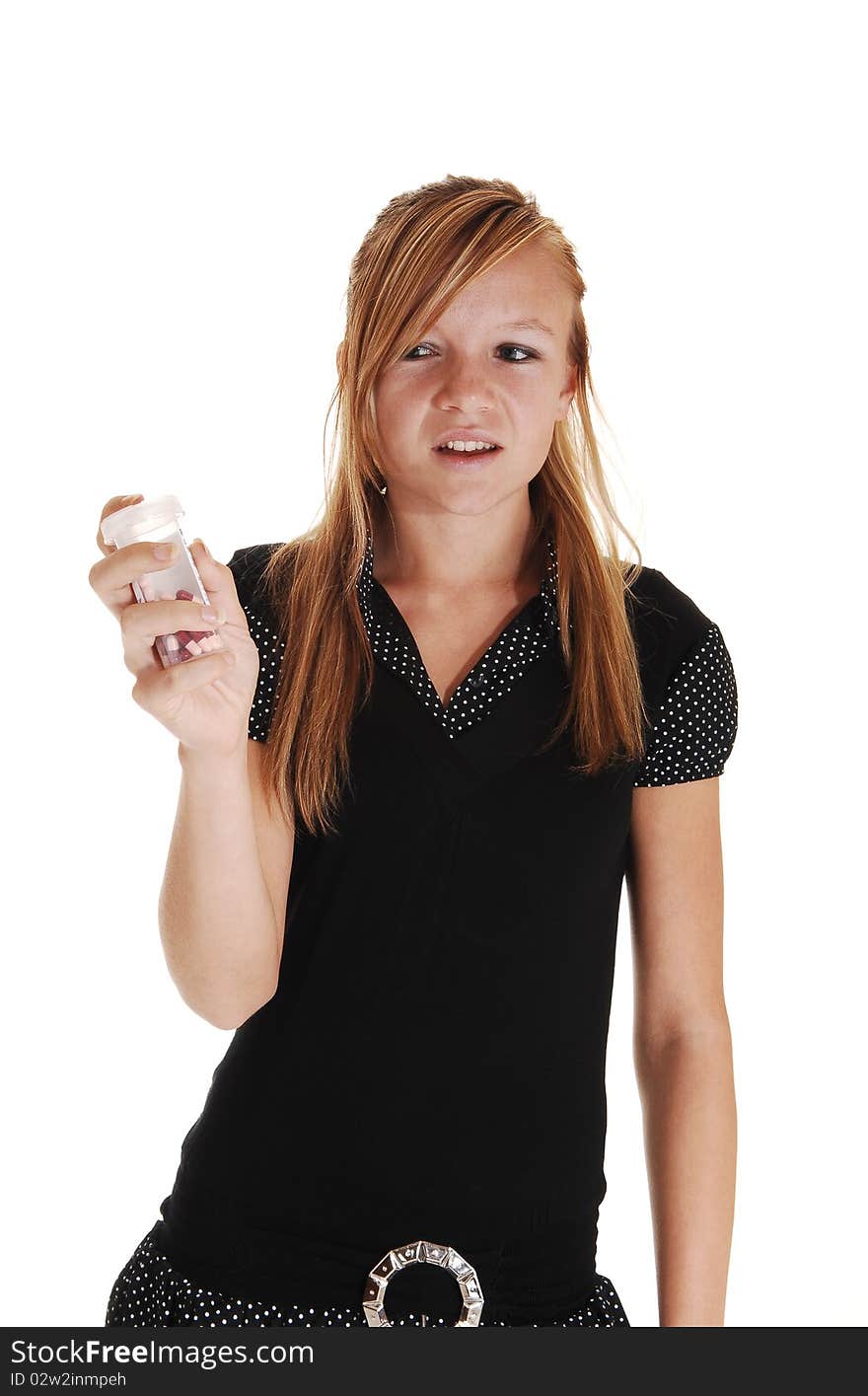 A young pretty woman in a black dress, standing in the studio and holding
a bottle of pills in her hand, but she likes not to take them, over white. A young pretty woman in a black dress, standing in the studio and holding
a bottle of pills in her hand, but she likes not to take them, over white.