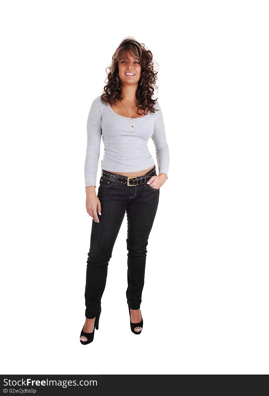 An pretty brunet woman in jeans and a gray sweater with long sleeves and high heels standing in the studio, for white background. An pretty brunet woman in jeans and a gray sweater with long sleeves and high heels standing in the studio, for white background.