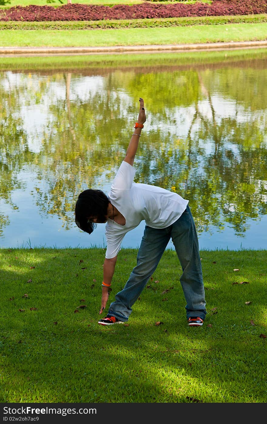 A girl were exercising in the park. A girl were exercising in the park.