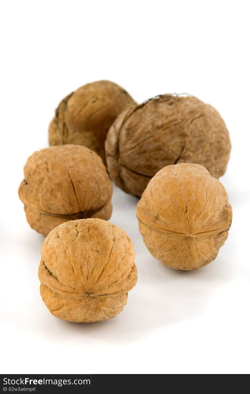 Five walnuts on white background