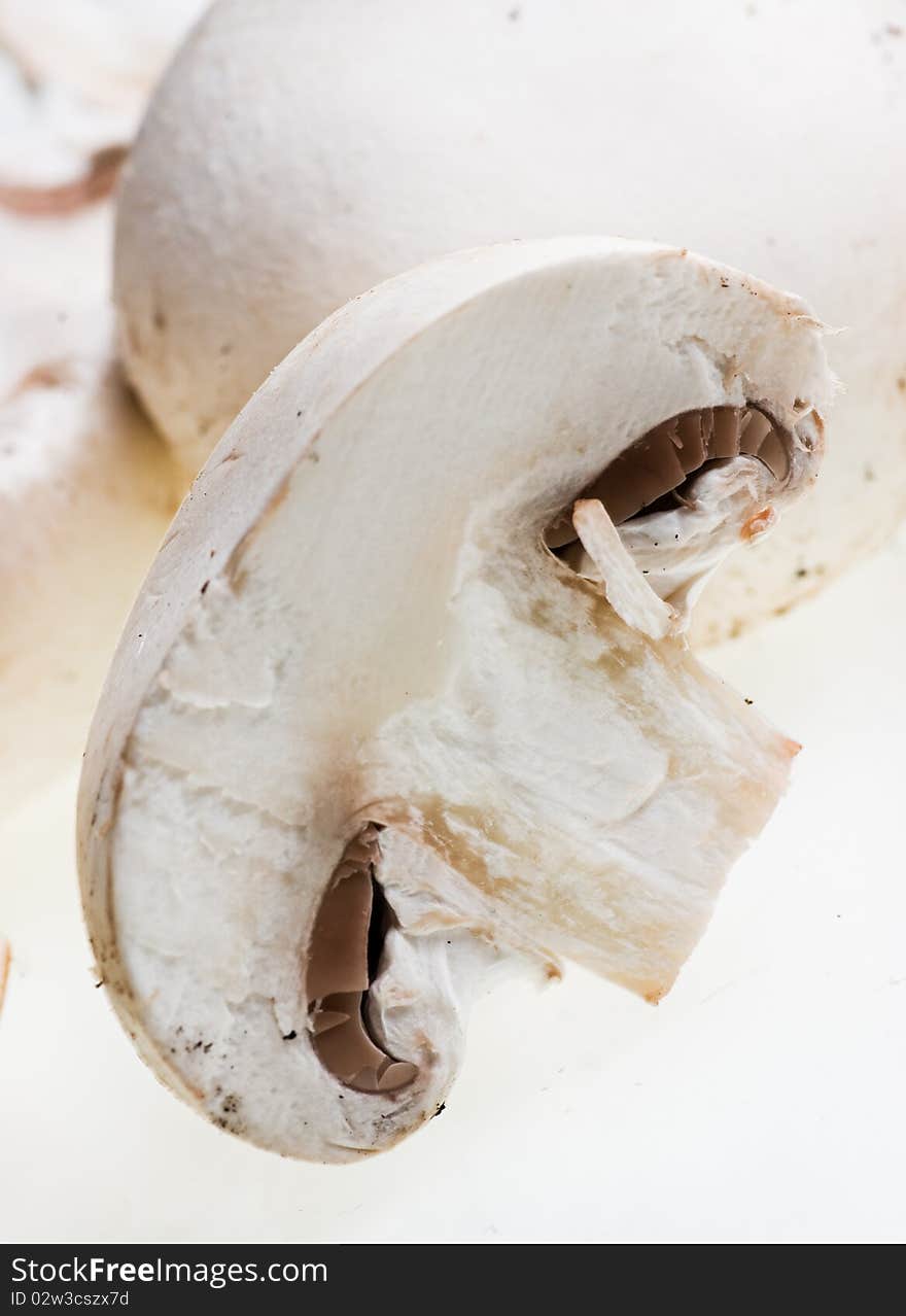 Champignons and a cut one on a white background