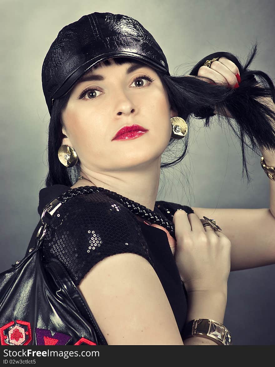 Photo of fashionable young woman wearing a black hat with hand bag