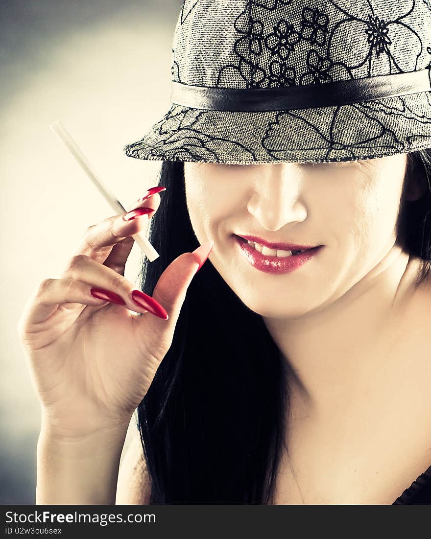 Beautiful smoking woman wearing hat