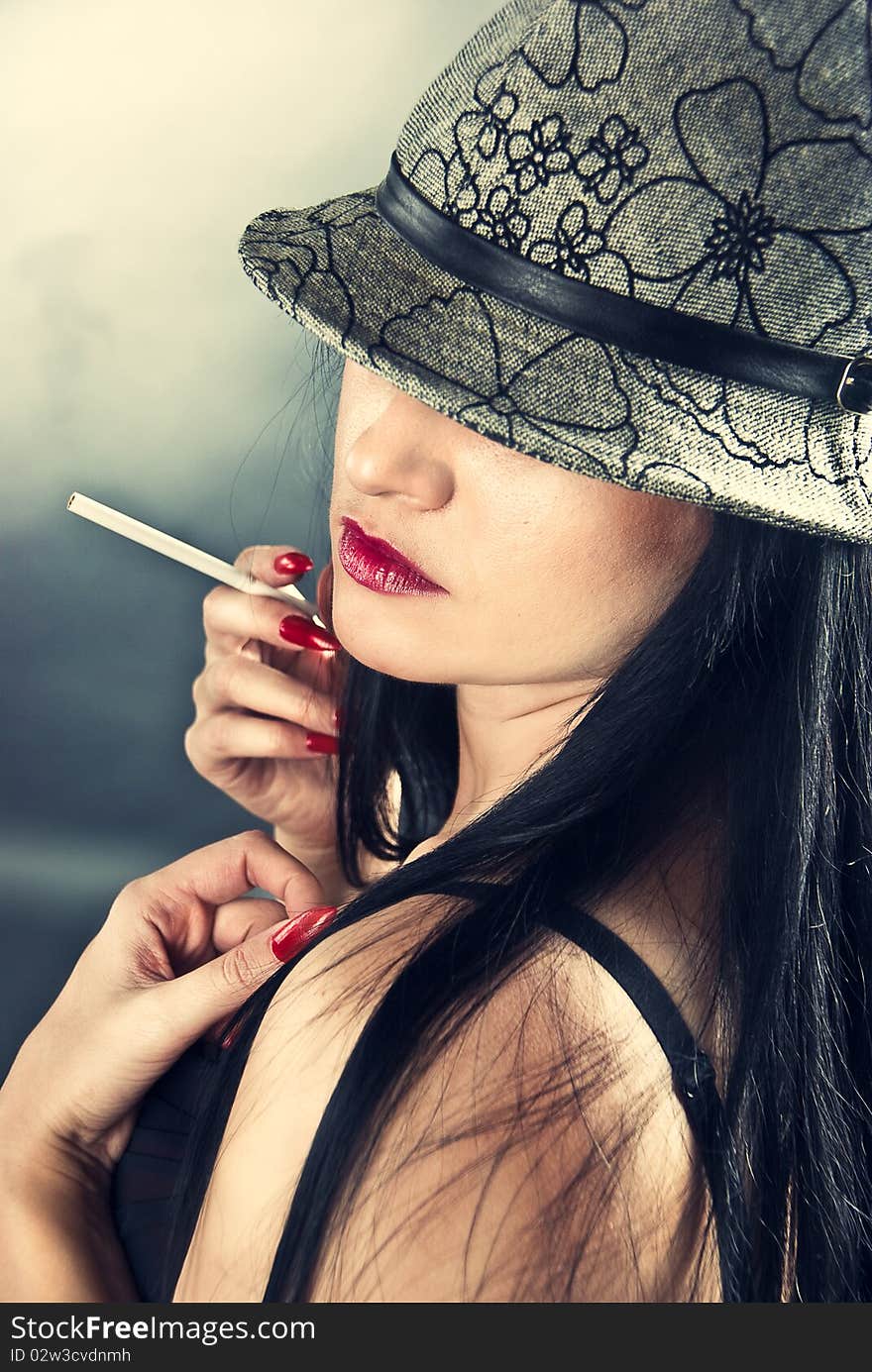 Beautiful smoking woman wearing hat