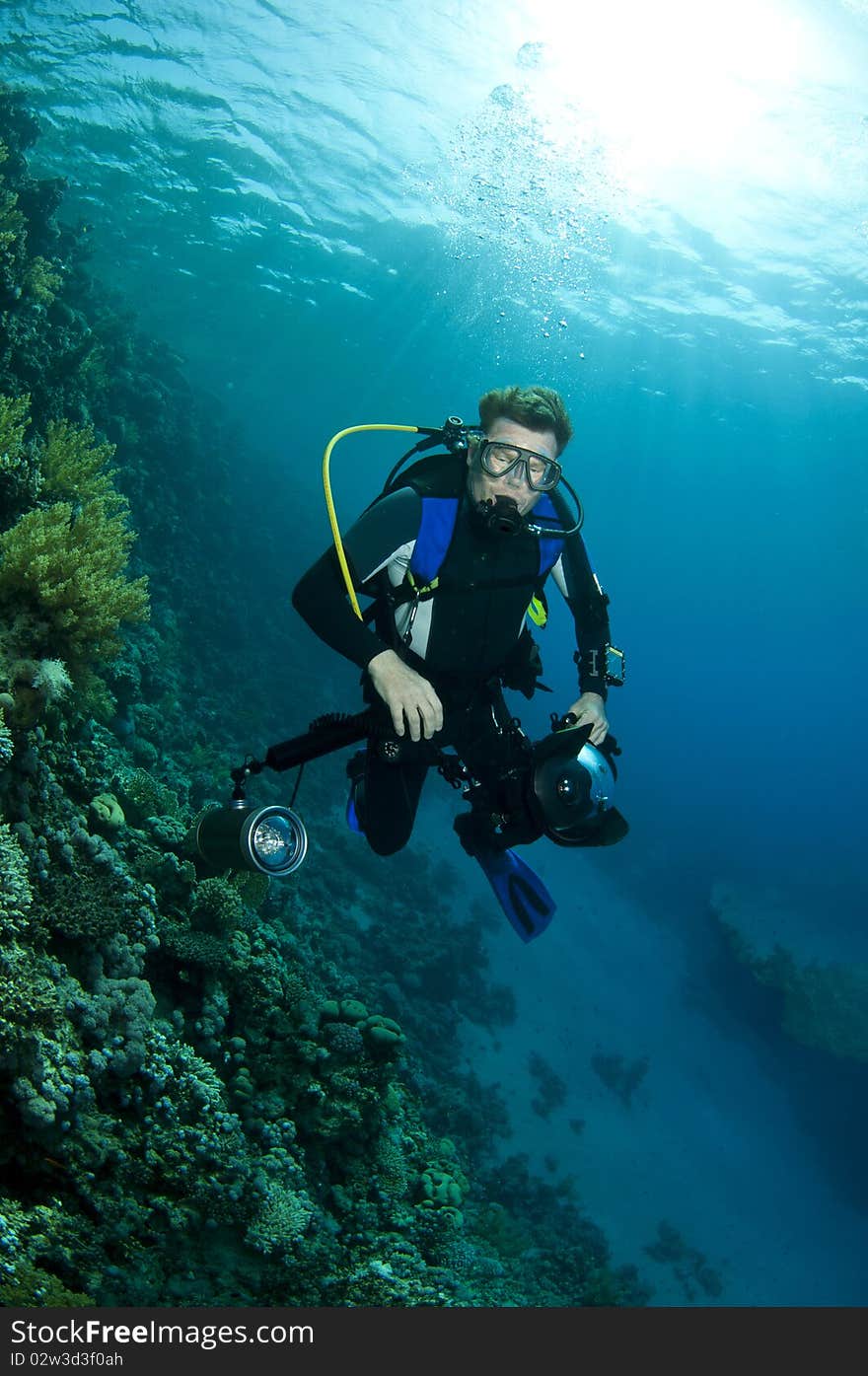 Camera man swims in clear blue water. Camera man swims in clear blue water