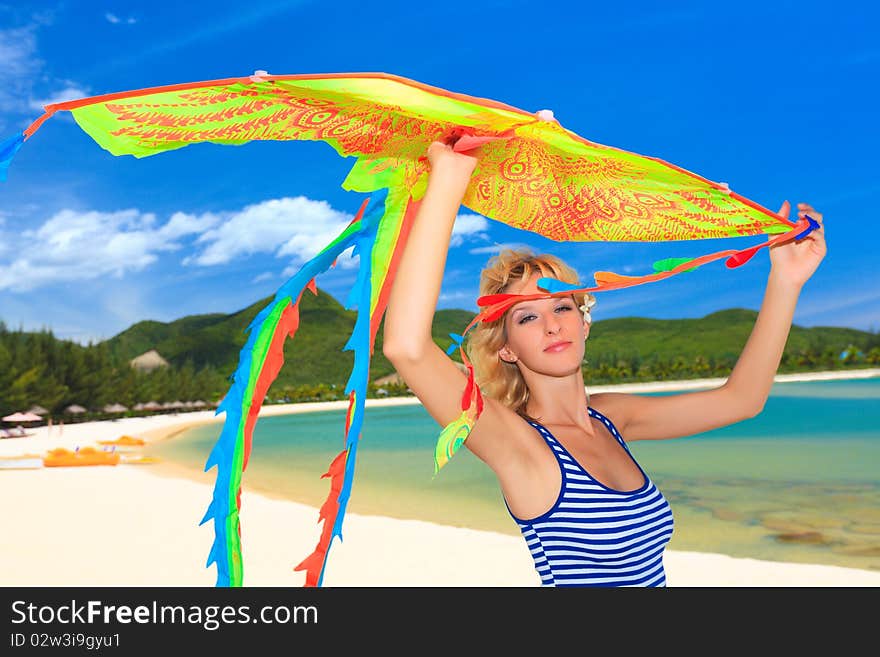 Young woman with kite on the beach