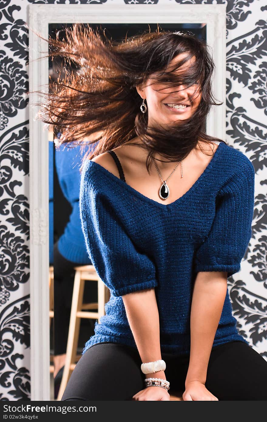 Portrait of attractive woman with hair is shuffled by the wind on a background of mirror. Portrait of attractive woman with hair is shuffled by the wind on a background of mirror