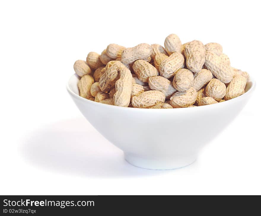 White bowl with unshelled peanuts