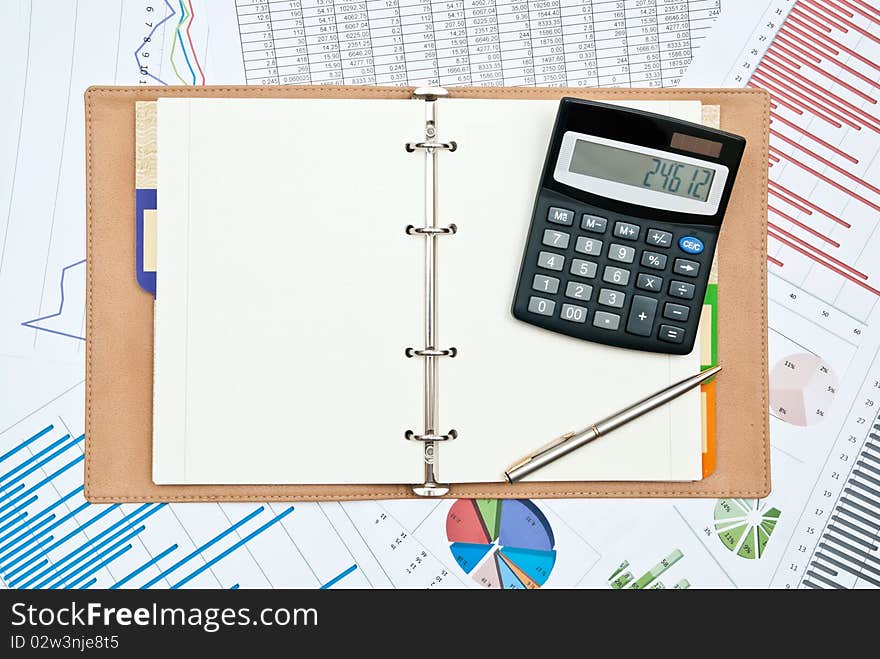 Financial charts with calculator,pen,notebook and pen. Financial charts with calculator,pen,notebook and pen