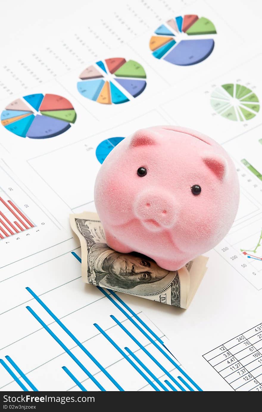 Piggy bank on money with business charts. Piggy bank on money with business charts