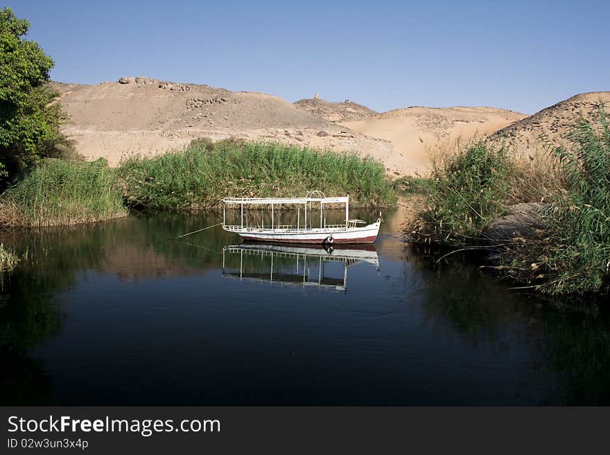 An Egyptian fisherman's boat on a blue lake in the dessert. An Egyptian fisherman's boat on a blue lake in the dessert