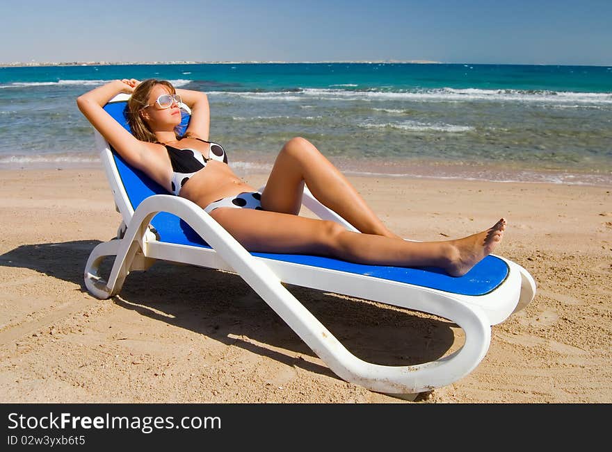 Cute woman on a plank bed at the sea