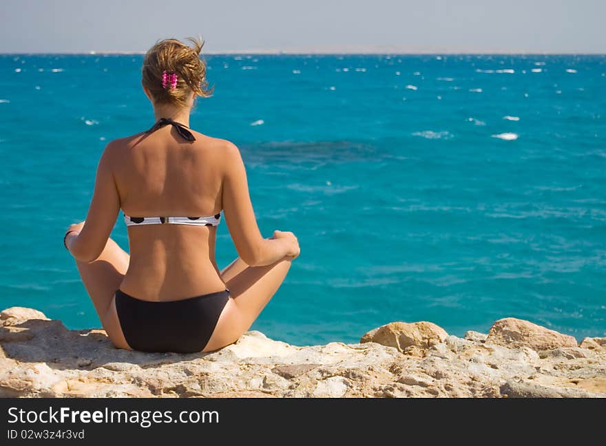 Woman In A Sarong Meditating On The Beach