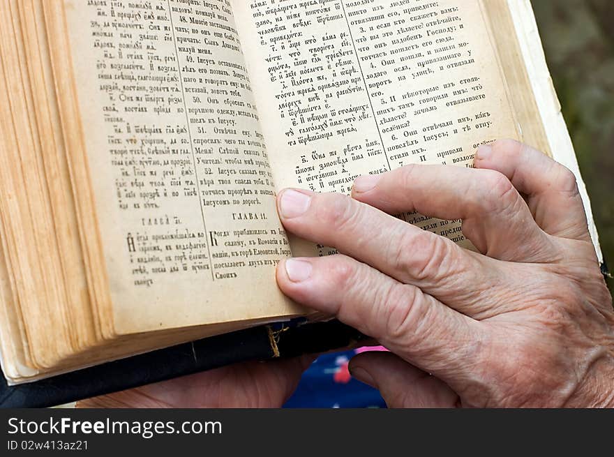 The old woman reads the bible close up