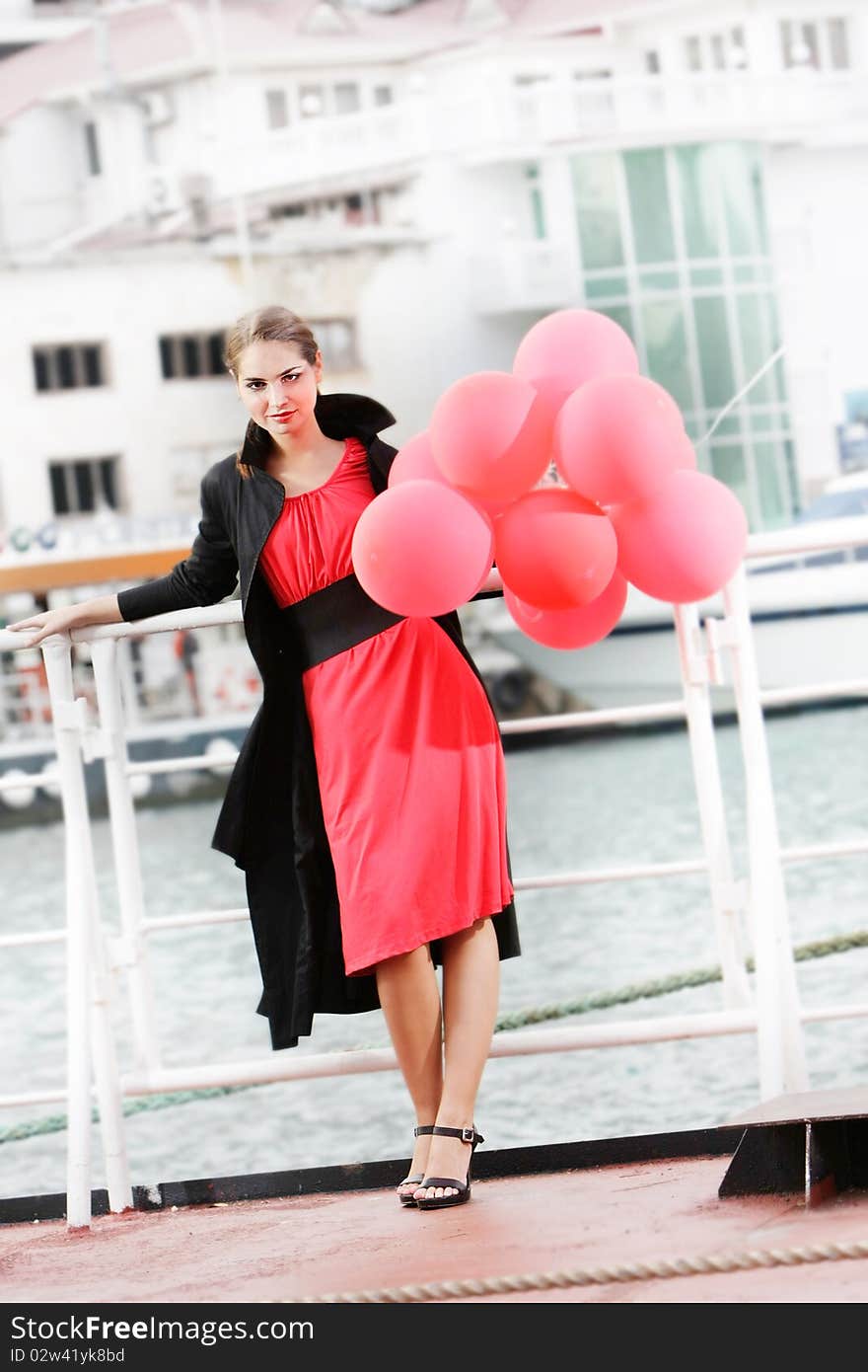 Attractive young woman with red balloons on urban background. Attractive young woman with red balloons on urban background