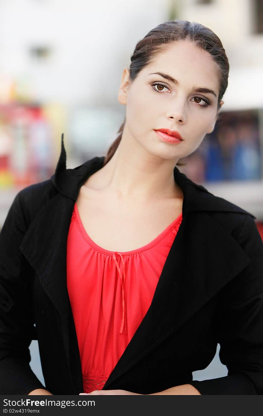 Alone young woman on blurred urban background