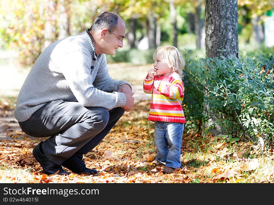 Father and daughter on autumn park backgro