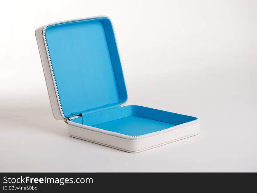 A horizontal image of a white leather zip case for makeup