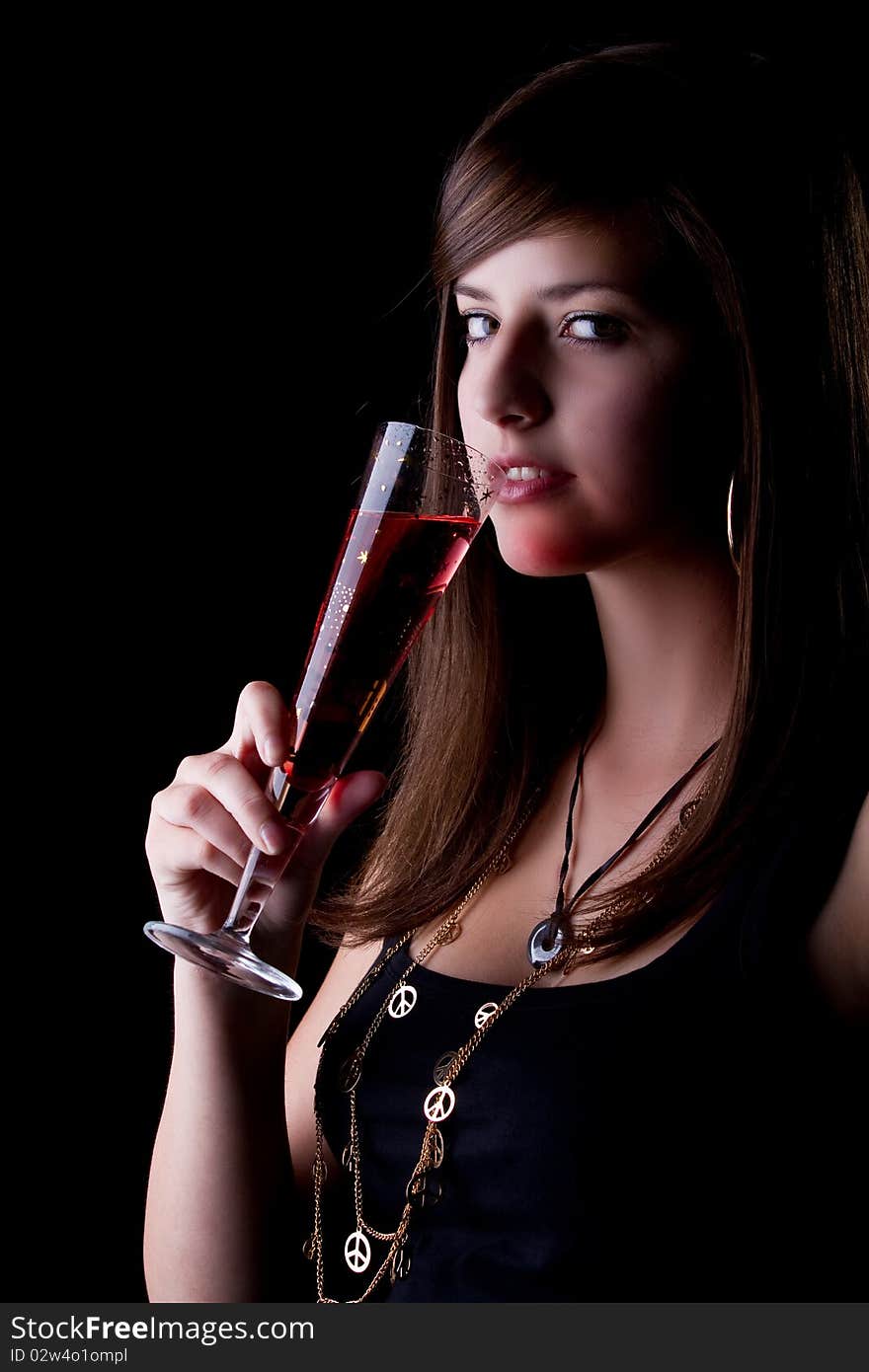 Young teenage party girl with a red drink. Isolated over black background. Young teenage party girl with a red drink. Isolated over black background.