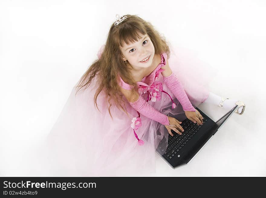 Little girl the princess plays with the notebook. White background. Little girl the princess plays with the notebook. White background