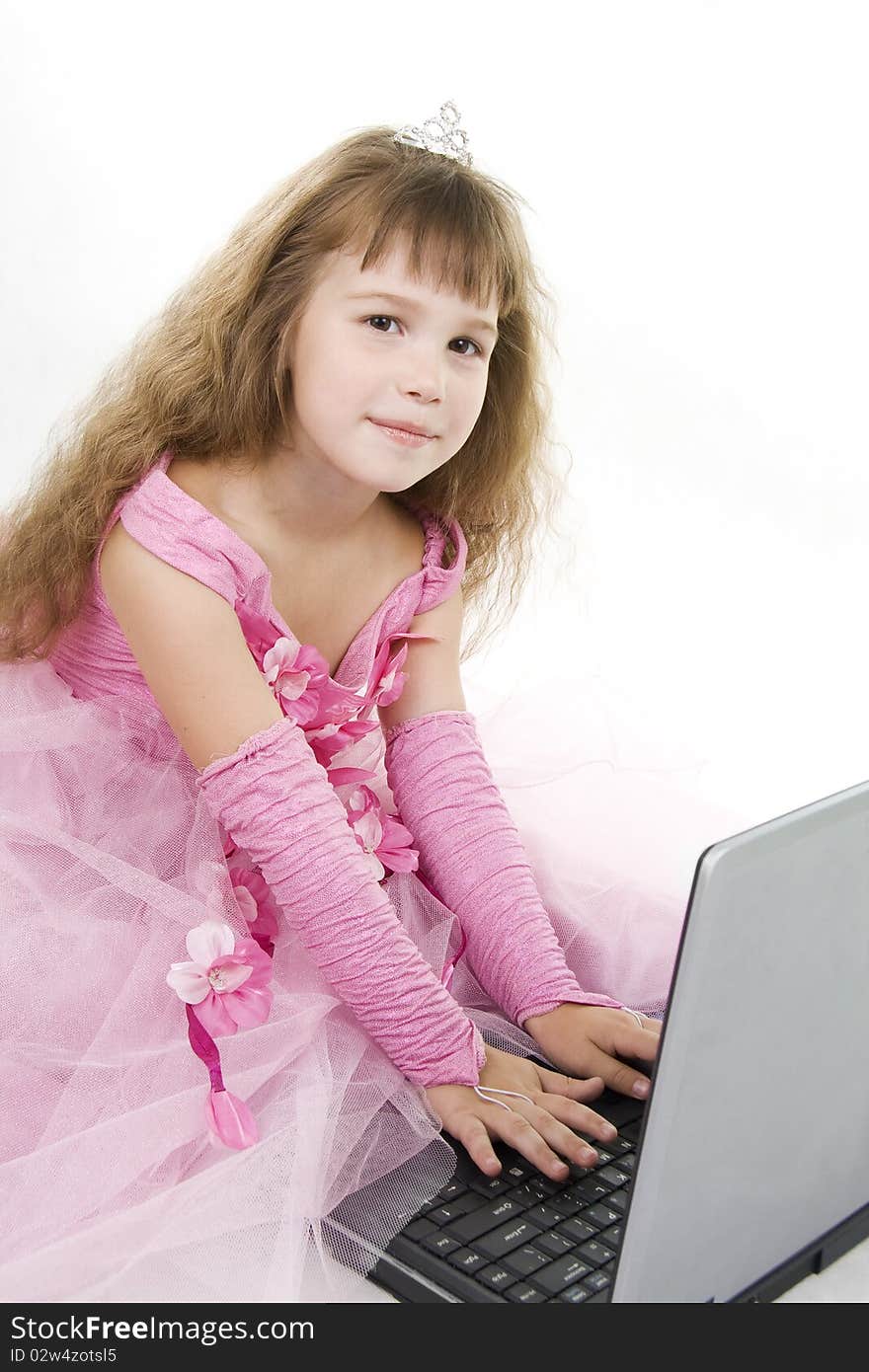 Little girl the princess plays with the notebook. White background. Little girl the princess plays with the notebook. White background