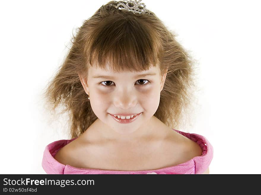 The girl the princess in a pink dress sits opposite to a white background. The girl the princess in a pink dress sits opposite to a white background