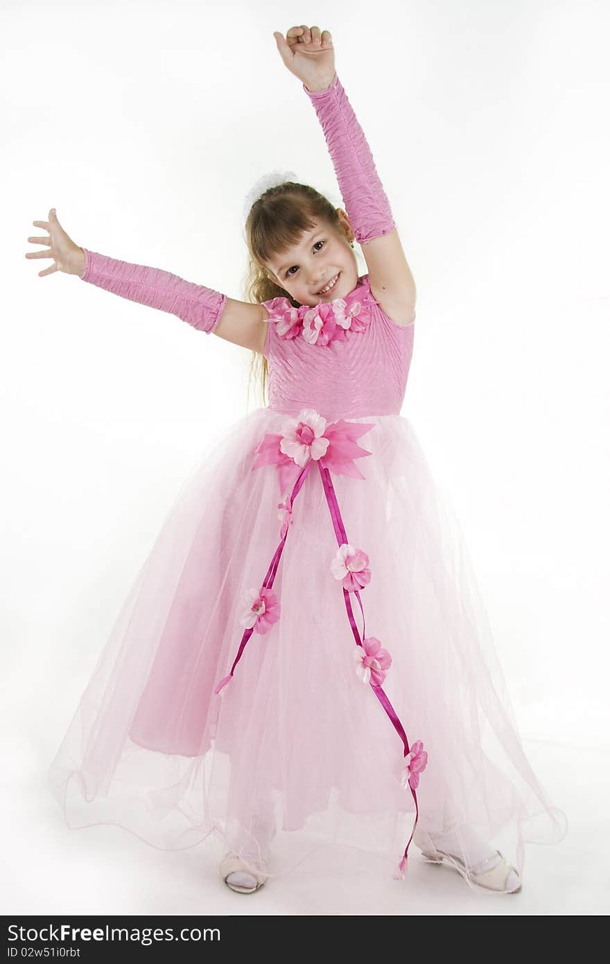 The girl the princess in a pink dress sits opposite to a white background. The girl the princess in a pink dress sits opposite to a white background