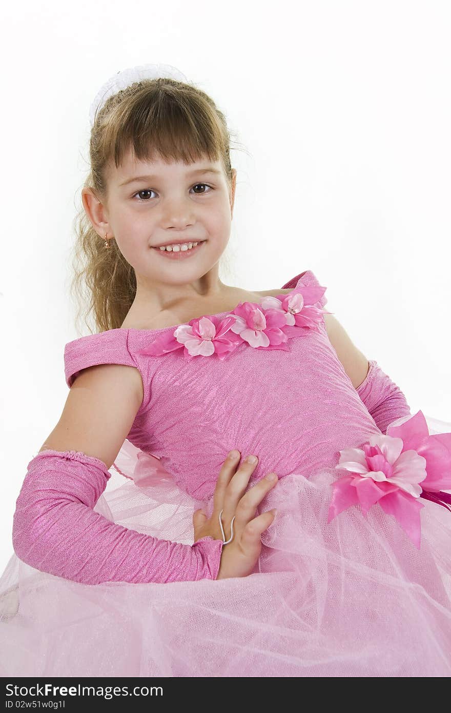 The girl the princess in a pink dress sits opposite to a white background. The girl the princess in a pink dress sits opposite to a white background