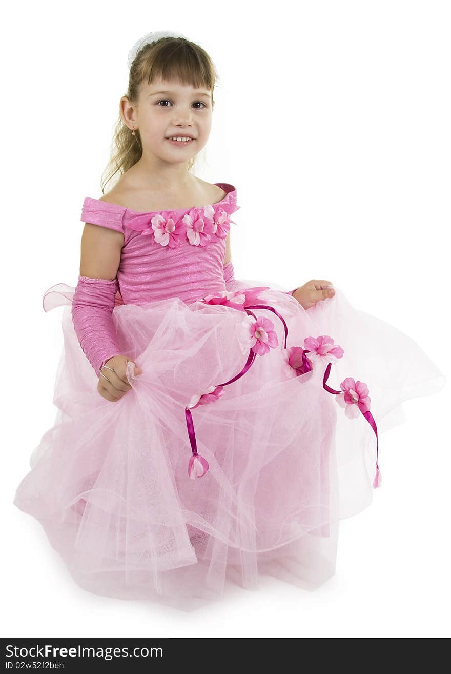 The girl the princess in a pink dress sits opposite to a white background. The girl the princess in a pink dress sits opposite to a white background